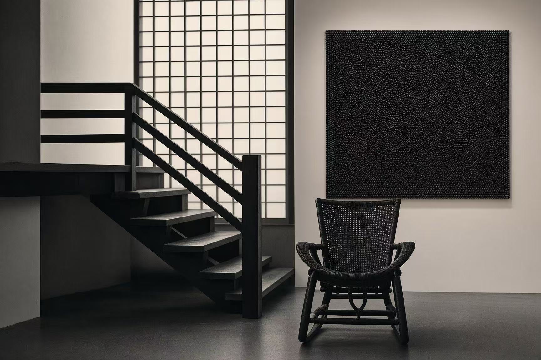 Udiri Studio interior with staircase, woven chair and textured artwork